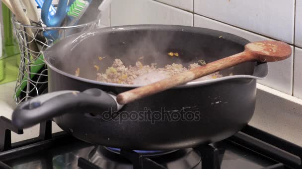 Сковородка с фаршем, приготовленной на плите на кухне — стоковое видео