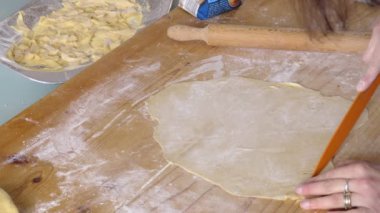 taze makarna yapmak için hamur, bıçak ve un ile çalışan uzman İtalyan kadın