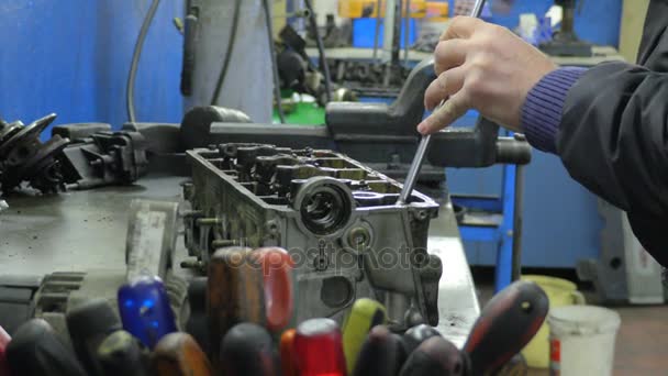 El taller de mecanicalina el destornillador mecánico y monta piezas en su escritorio — Vídeos de Stock