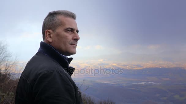 Az érett férfi szemlélve a horizonton, egy ködös nap profilja — Stock videók