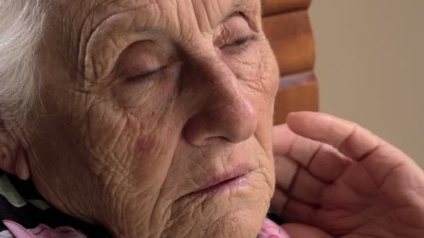 Закрыть кадры о беспокойной и задумчивой старухе, трогающей волосы — стоковое видео