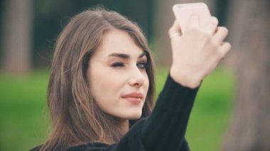 Güzel genç kadın selfie parkta alır.