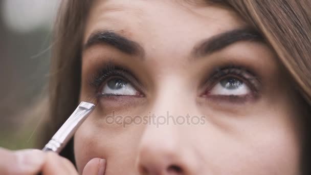 Artiste maquillage portant le maquillage sur les yeux du beau modèle — Video