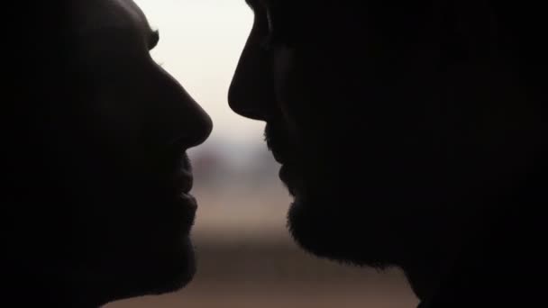 Gros plan sur Silhouette d'hommes s'embrassant dans la bouche — Video