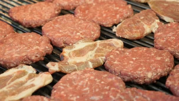 Fechar em Burgers e costeletas de porco assar no churrasco — Vídeo de Stock