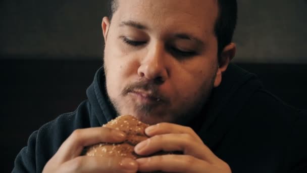 Close-up op een hongerige man die een vraatzuchtige Hamburger grijpt — Stockvideo