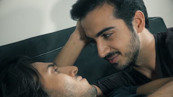 Portret van zoete homo paar liggend op bed een tedere kus geven — Stockvideo