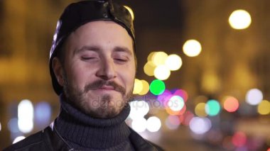 Gülümseyen, gece ışıklar arka plan ile yakışıklı adam