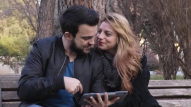 tablet bilgisayar kullanarak bir parkta genç çekici çift