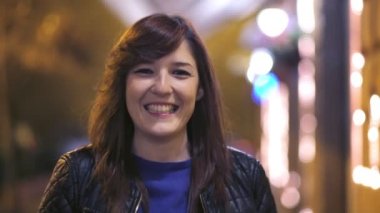 sokakta yürüyen ve kameraya, geceleri gülümseyen bulanık sevimli kadın