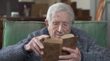  Kitap evde koltukta oturan yaşlı adam okur