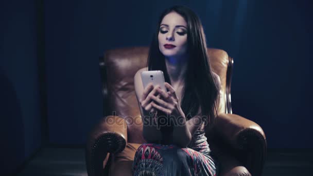 Retrato de mulher sofisticada e bonita digitando no smartphone sentado — Vídeo de Stock