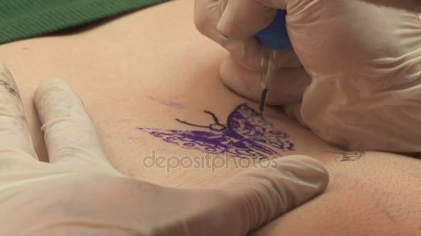 Tatuaggio artista disegnato una farfalla sulla pancia di una donna — Video Stock