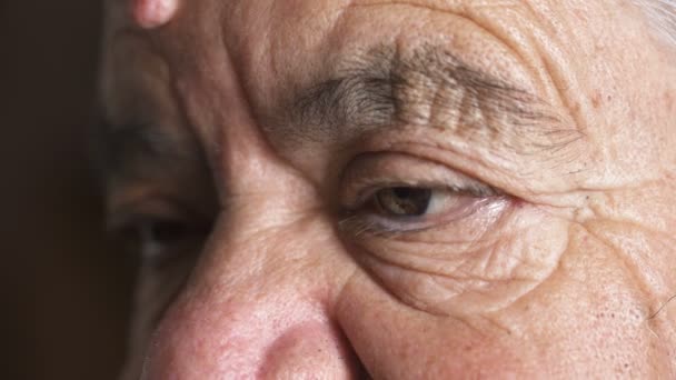 Cerca de los ojos arrugados de la triste anciana — Vídeos de Stock