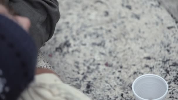 Бездомные просыпаются, когда кто-то оставляет монету в стакане. — стоковое видео