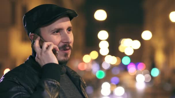 Heureux homme souriant parlant sur téléphone portable dans la rue la nuit — Video