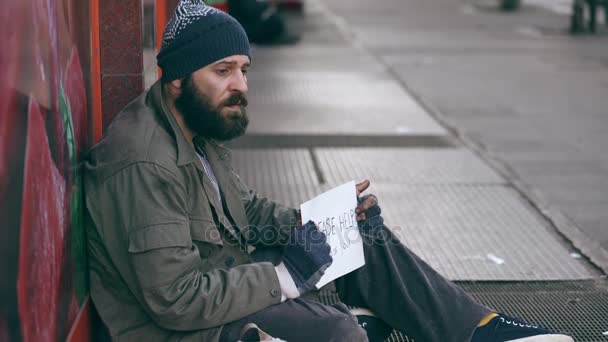 Samotny smutny bezdomnych siedzący na ulicy prosząc o jałmużnę — Wideo stockowe
