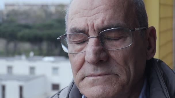 Ledsen och omtänksamma mannen på balkongen sluter sina ögon — Stockvideo
