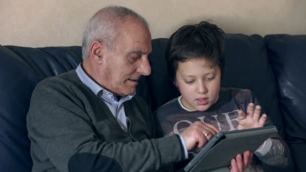 Retrato del abuelo con el nieto usando la tableta en el sofá — Vídeo de stock