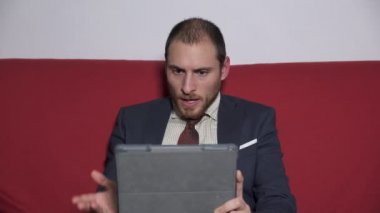 Ciddi iş adamı tablete ortağı ile konuşmak