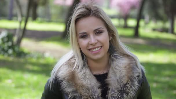 Boldog aranyos szőke nő mosolyogva a kamera Park — Stock videók