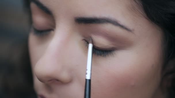 Close up on Maquiagem mão do artista aplicando com uma sombra de pincel no olho — Vídeo de Stock