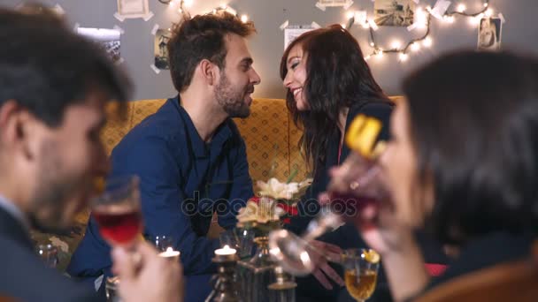 Молодая женщина и мужчина флиртуют и целуются во время вечеринки — стоковое видео