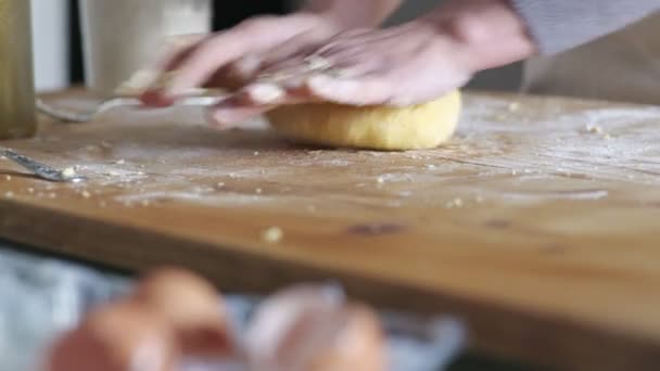 Руки домохозяйки смешивают тесто на деревянной доске — стоковое видео