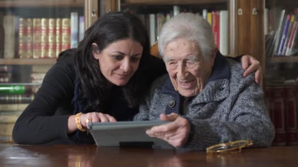 Grandaughter 그녀의 오래 된 할아버지는 태블릿 작동 하는 방법을 설명합니다 — 비디오
