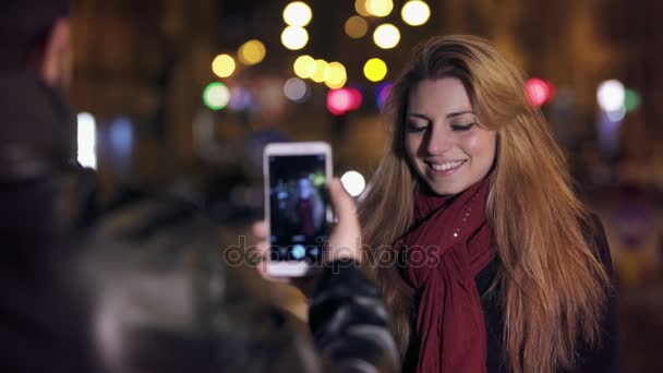 Novio toma una foto a la linda chica en la ciudad noches — Vídeo de stock