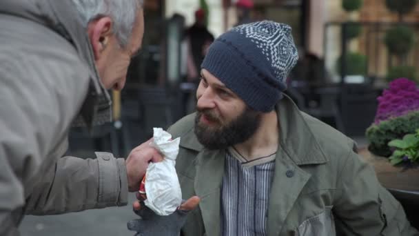 Hambrientos sin hogar recibe desayuno de un viejo caballero — Vídeo de stock