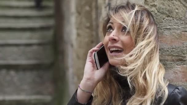 Ближе к очаровательной женщине, говорящей по телефону улыбаясь — стоковое видео