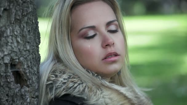 Triste mujer rubia deprimida llorando en el parque — Vídeo de stock