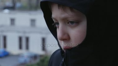 Üzgün ve düşünceli çocuk ile balck kukuleta, açık yukarıya kapatmak