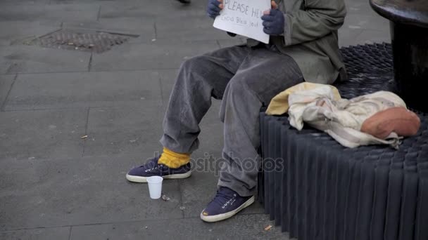 Портрет нищего сидит на улице, мужчина помогает ему с едой и кофе — стоковое видео