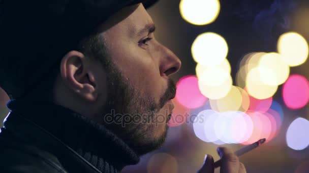 Profile of thoughtfu,sad man smoking cigarette at night in the city — Stock Video