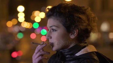 Düşünceli kadın geceleri kentin sigara içiyor, yakın çekim