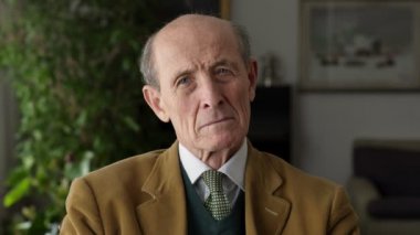 Dalgın ve ciddi yaşlı adam görünüyor kameraya, portre
