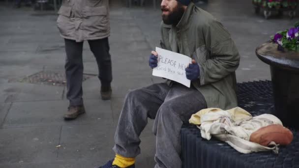 Retrato de anciano ofrece un croissant y un café caliente a un mendigo — Vídeo de stock