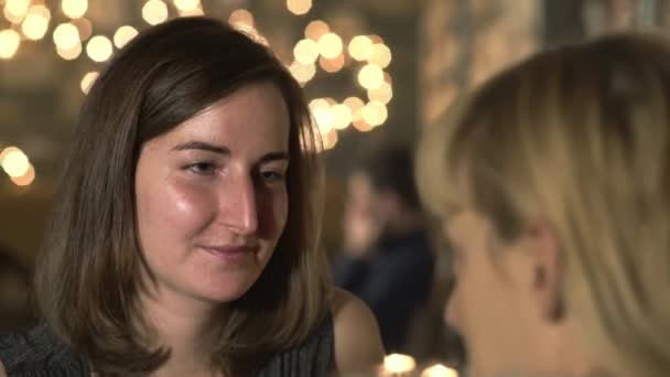 Улыбающаяся женщина разговаривает с другом в ресторане, закрывается — стоковое видео