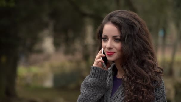 Gyönyörű barna flörtöl a telefon neki barátja-kültéri — Stock videók