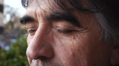 Gözleri ağır çekim düşünceli olgun adam açar