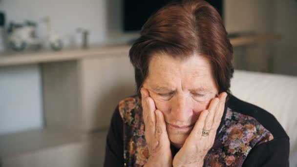 Closeup portret van een oude vrouw nadenkend en verdrietig thuis: doordachte ouderen — Stockvideo