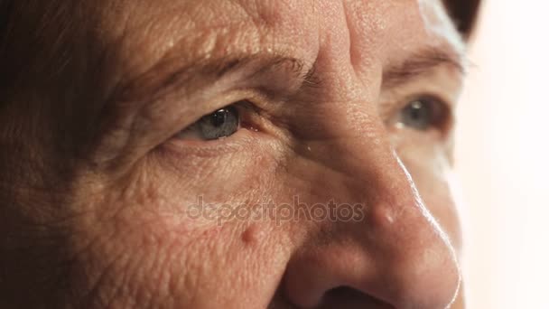 Primer plano Retrato en los ojos de una anciana: Retrato de una anciana pensativa — Vídeo de stock