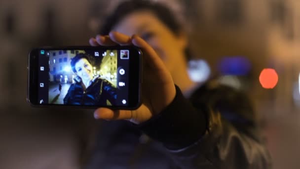 Mulher engraçada e bonita fica selfie com o smartphone, noite da cidade — Vídeo de Stock