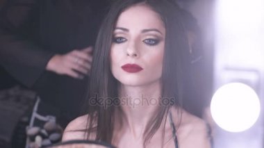 Saç stilisti saçını yumuşatır süre aynaya güzel model görünüyor