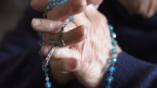Detailní záběr na rukou starší žena se modlí se růženec — Stock video