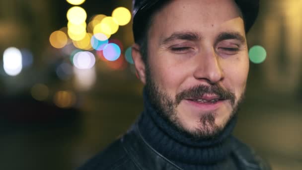 Чарівний чоловік посміхається на камеру в місті вночі — стокове відео
