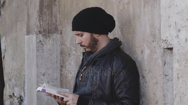 Joven concentrado en estudiar, apoyado en una pared — Vídeos de Stock