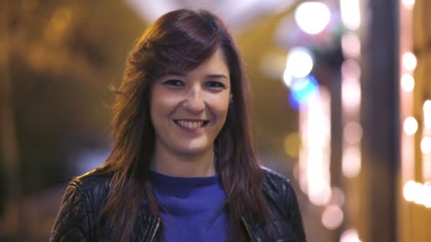 Roztomilá brunetka usmívá na fotoaparát v noci město zblízka — Stock video
